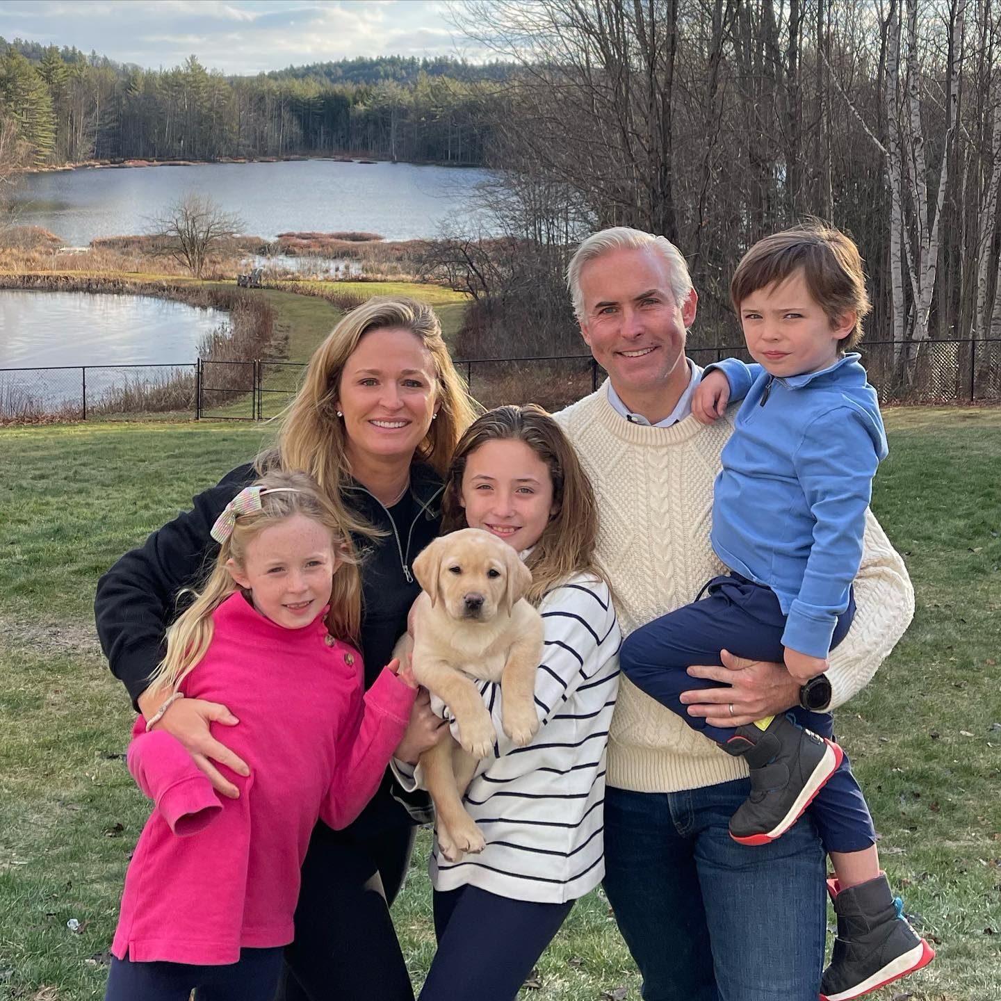 Happy family with their retriever puppy
