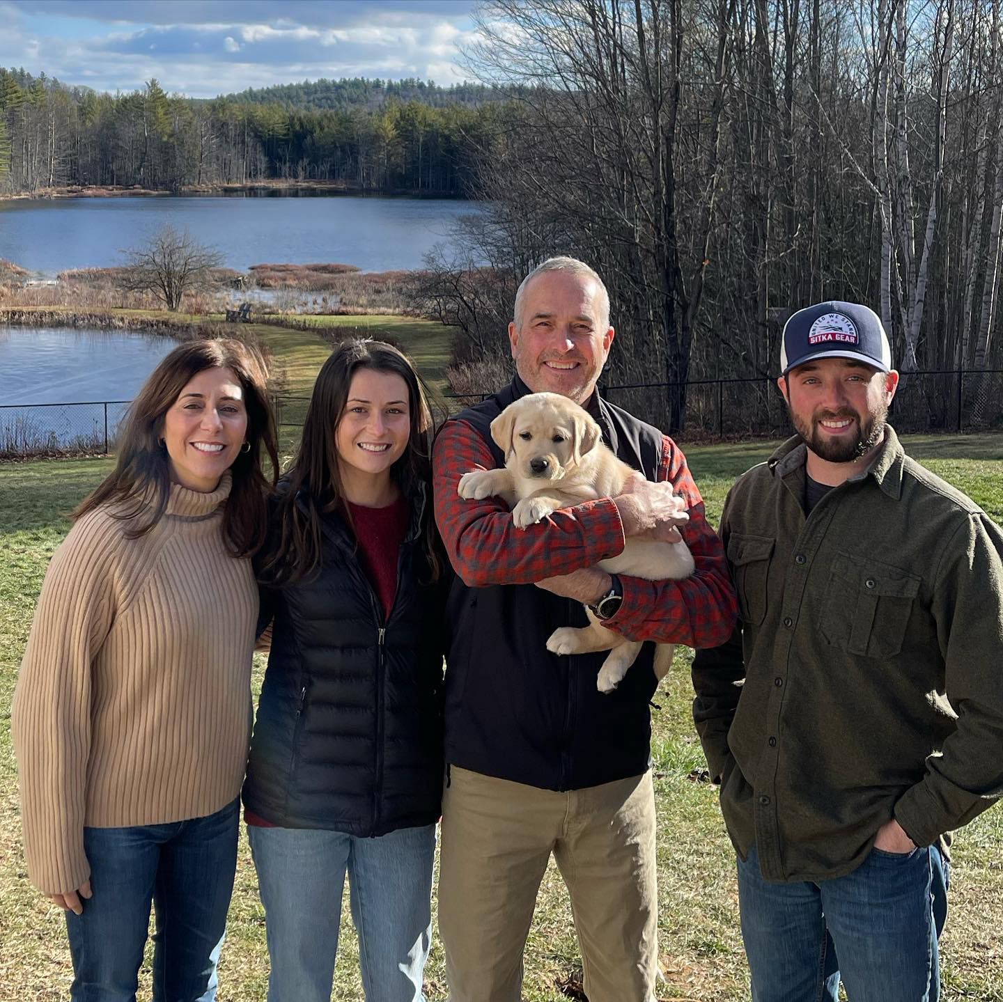 Happy family with their retriever puppy